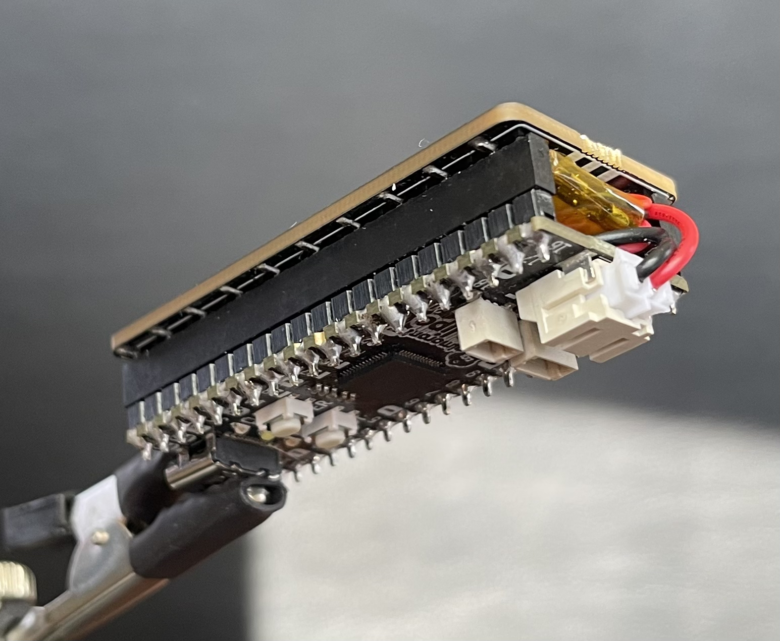 A fully assembled BumbleBee, with all 3 components. Shows the solder points, sockets, and battery connection