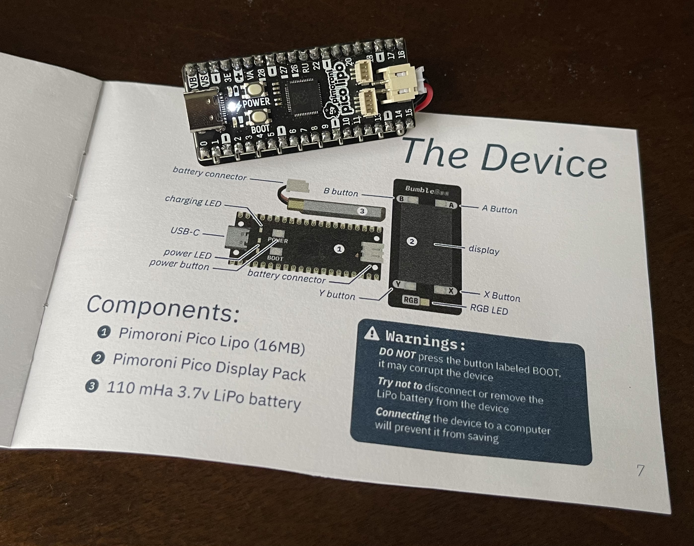 The BumbleBee sitting on its manual, open to the device page